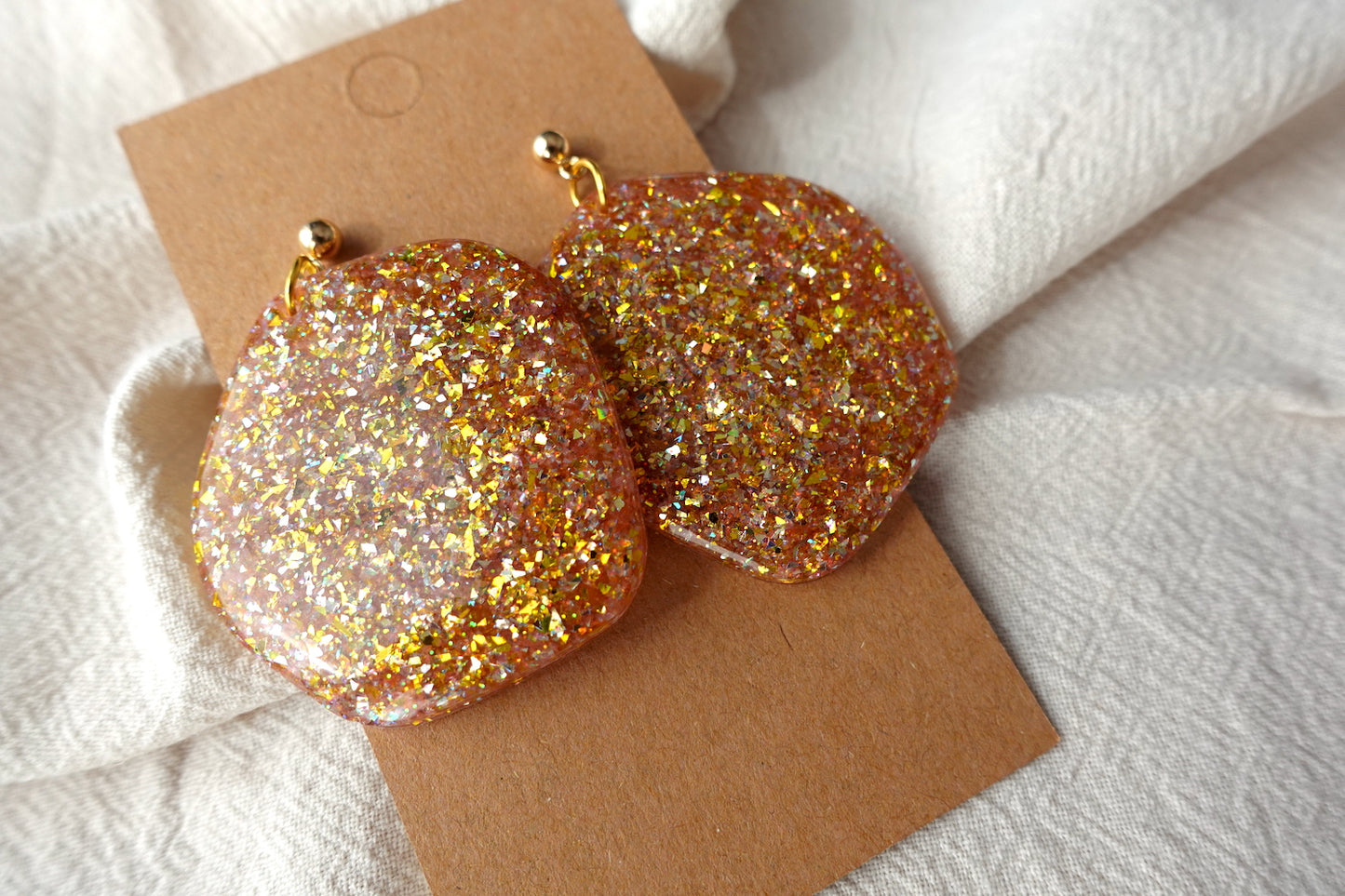 Organische goudkleurige oorbellen met holografische glitter - statement oorbellen