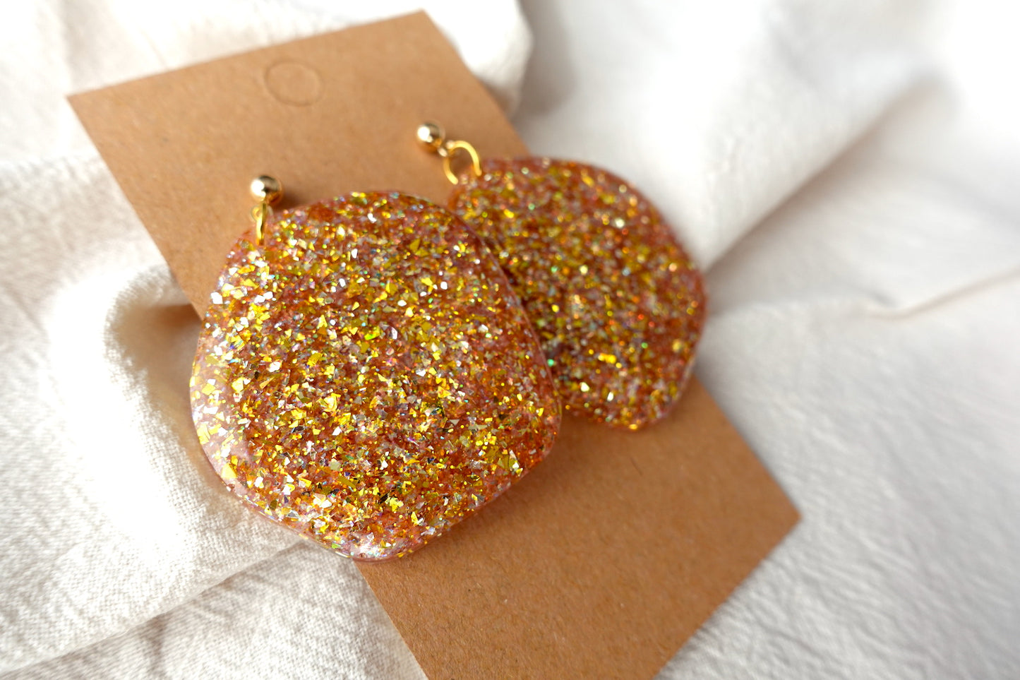 Organische goudkleurige oorbellen met holografische glitter - statement oorbellen