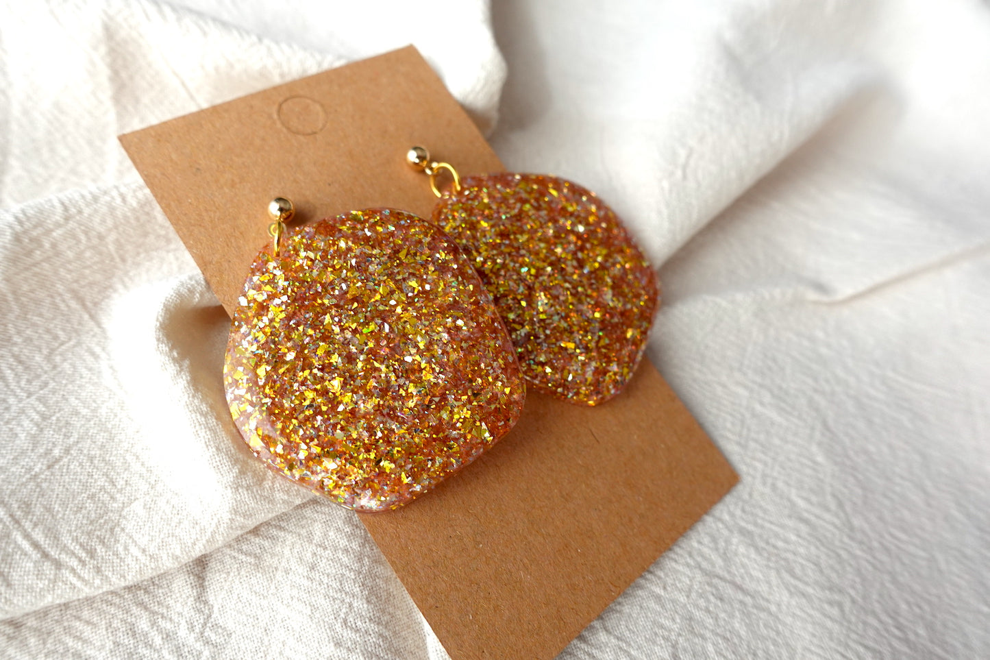 Organische goudkleurige oorbellen met holografische glitter - statement oorbellen