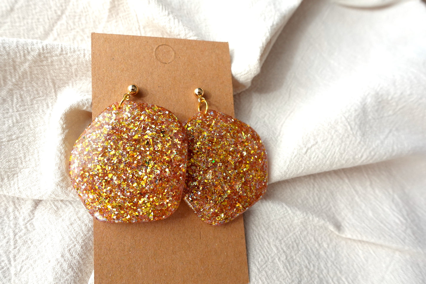 Organische goudkleurige oorbellen met holografische glitter - statement oorbellen