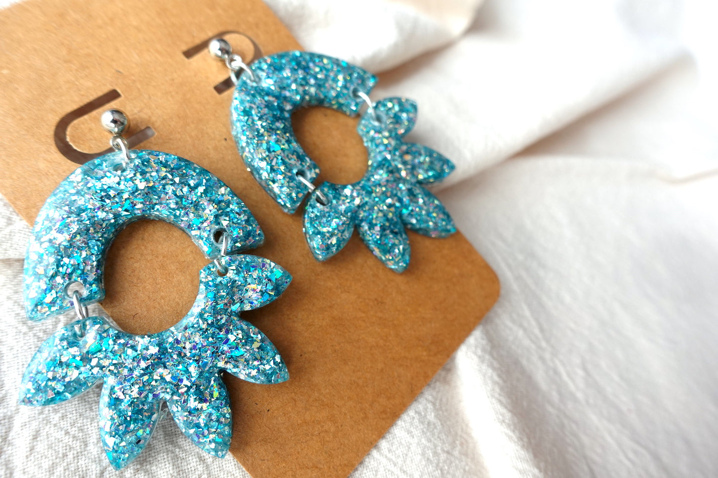 Halve bloem oorbellen lichtblauw met holografische glitter - statement oorbellen