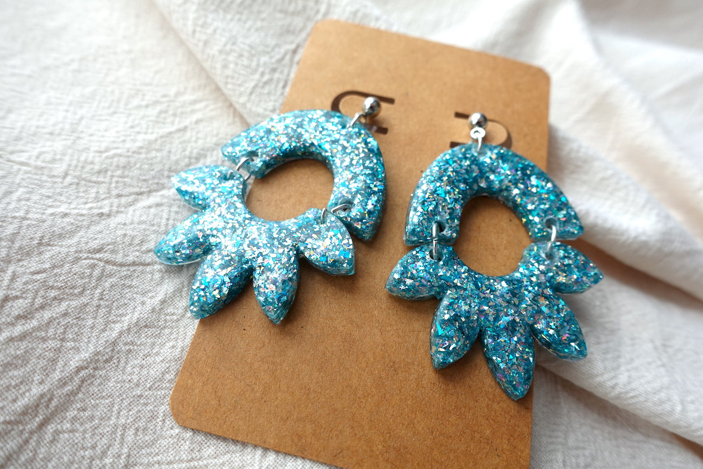 Halve bloem oorbellen lichtblauw met holografische glitter - statement oorbellen