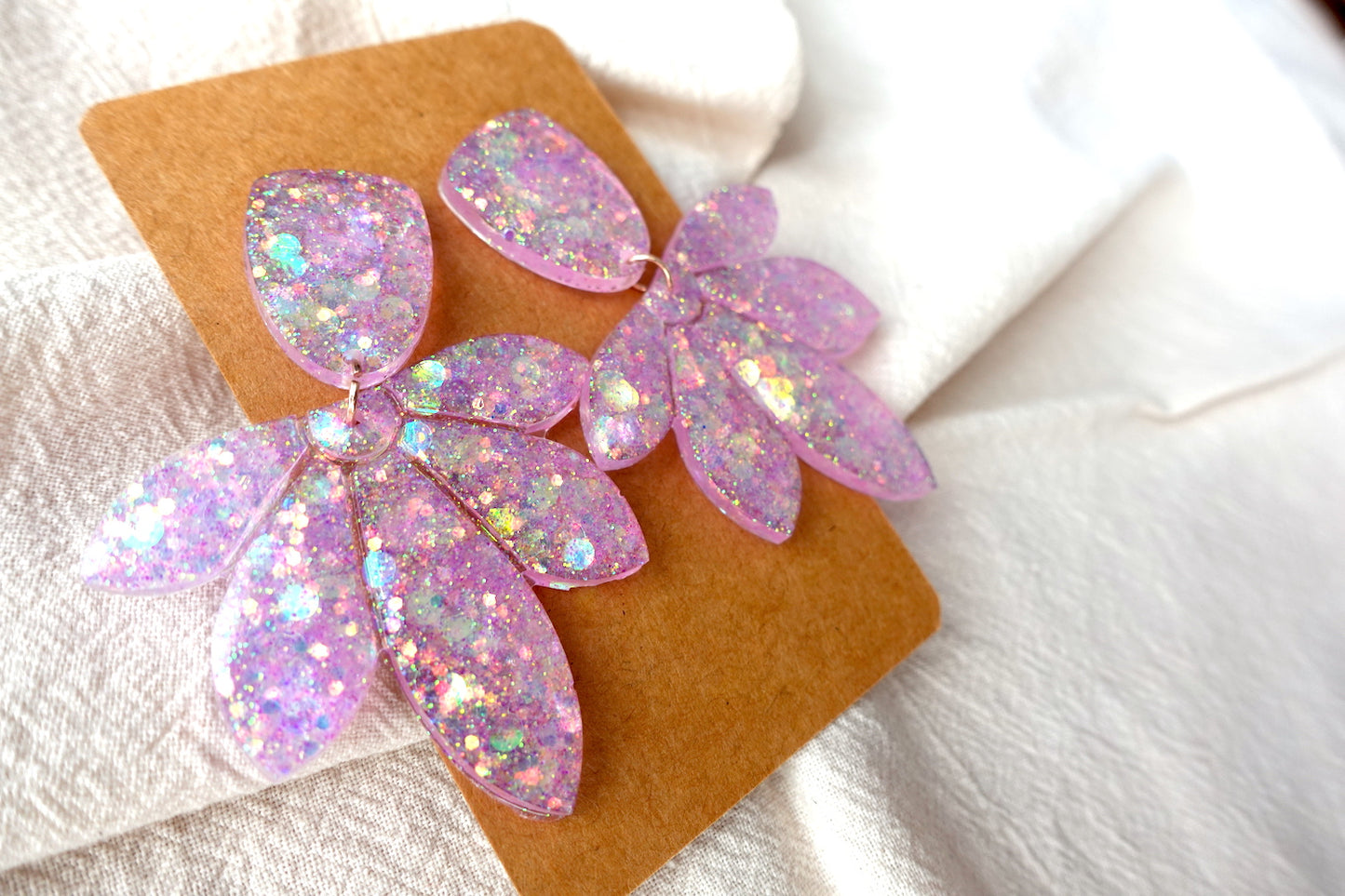 Bloem oorbellen doorzichtig lichtroze met glitter - statement oorbellen