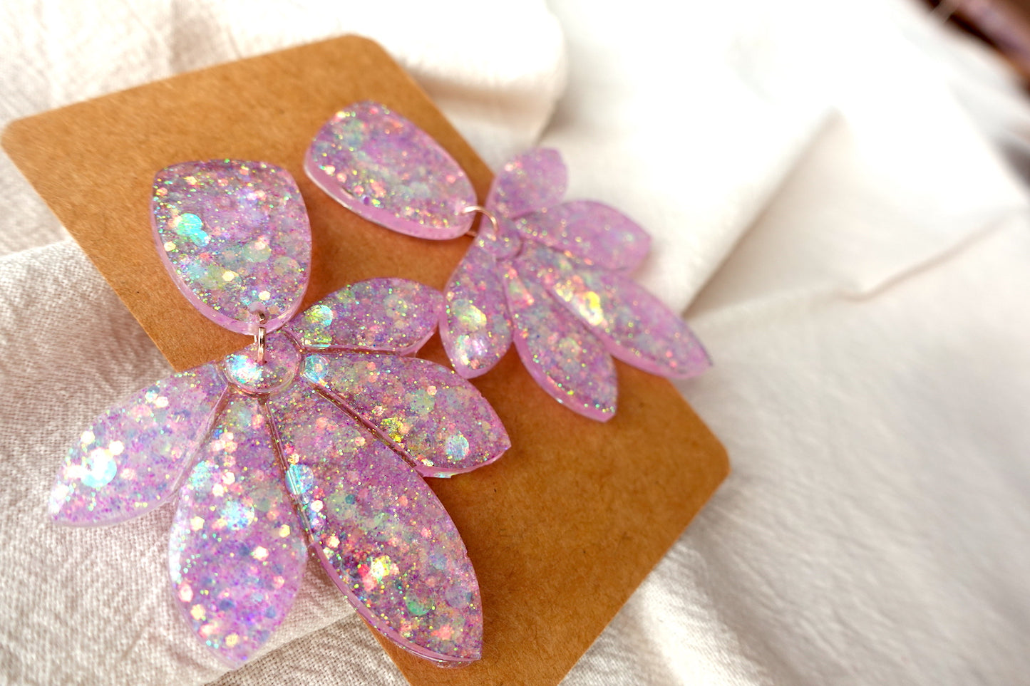 Bloem oorbellen doorzichtig lichtroze met glitter - statement oorbellen