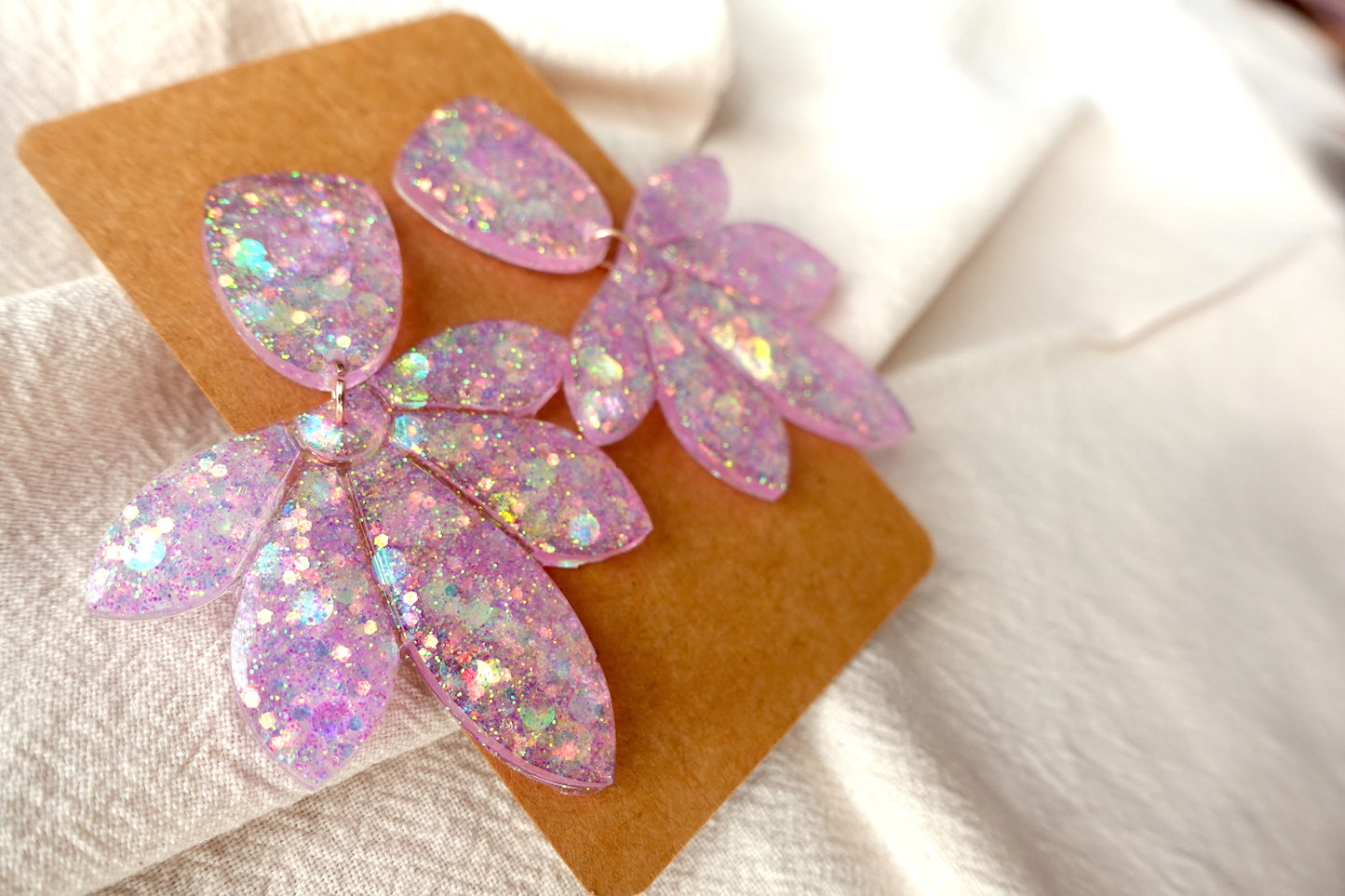 Bloem oorbellen doorzichtig lichtroze met glitter - statement oorbellen