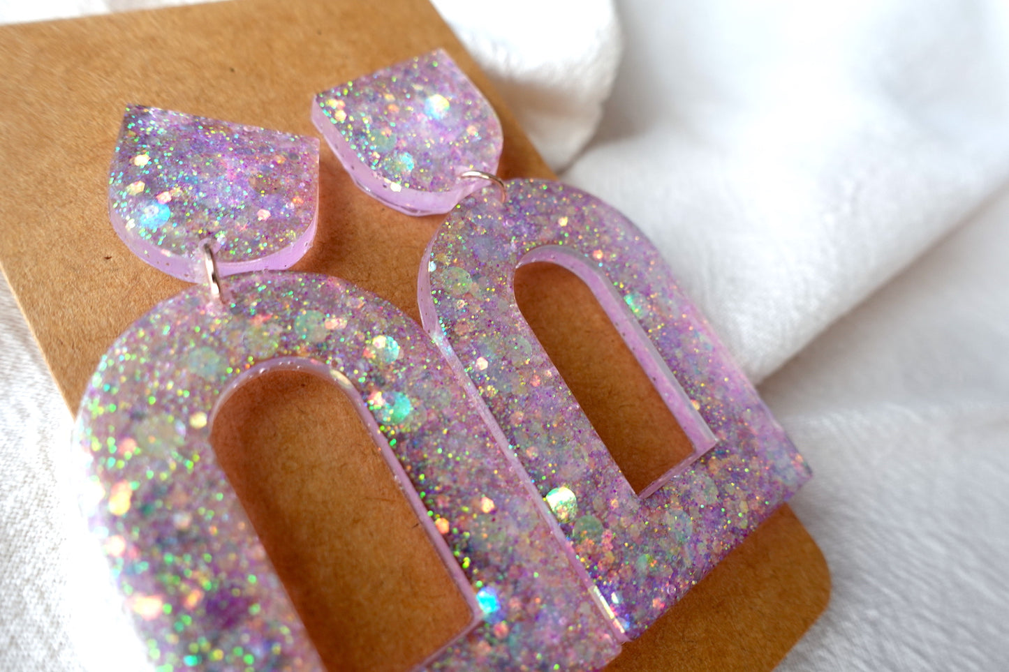 Boog oorbellen doorzichtig lichtroze met glitter - statement oorbellen