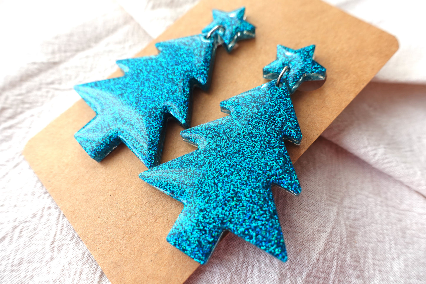 Holografische turquoise kerstboom oorbellen met sterretje