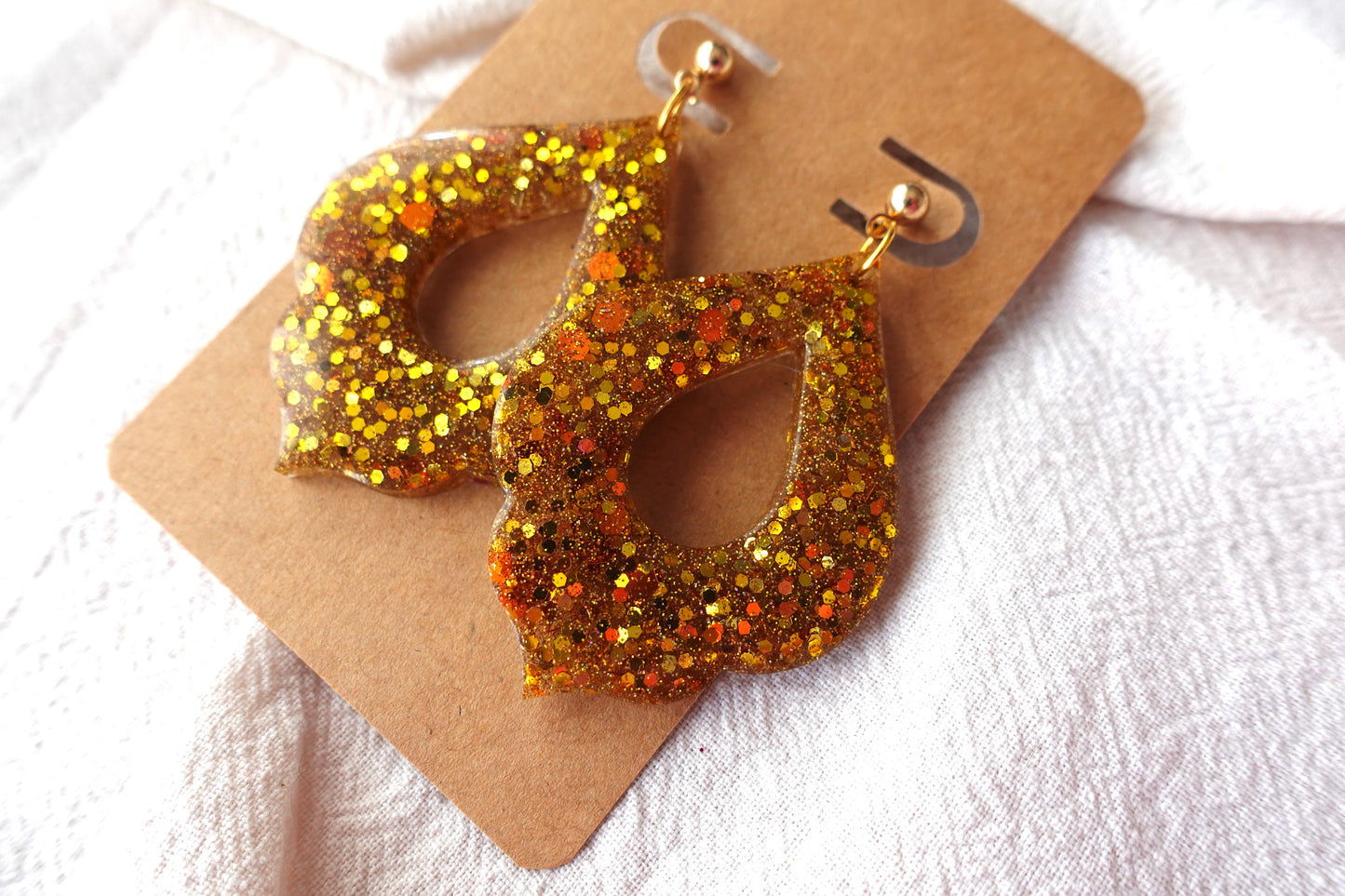Goudkleurige holografische glitter oorbellen (Marokkaanse donut) met goudkleurige knopjes