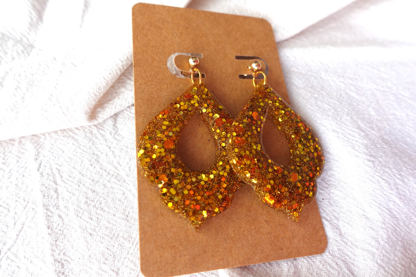 Goudkleurige holografische glitter oorbellen (Marokkaanse donut) met goudkleurige knopjes