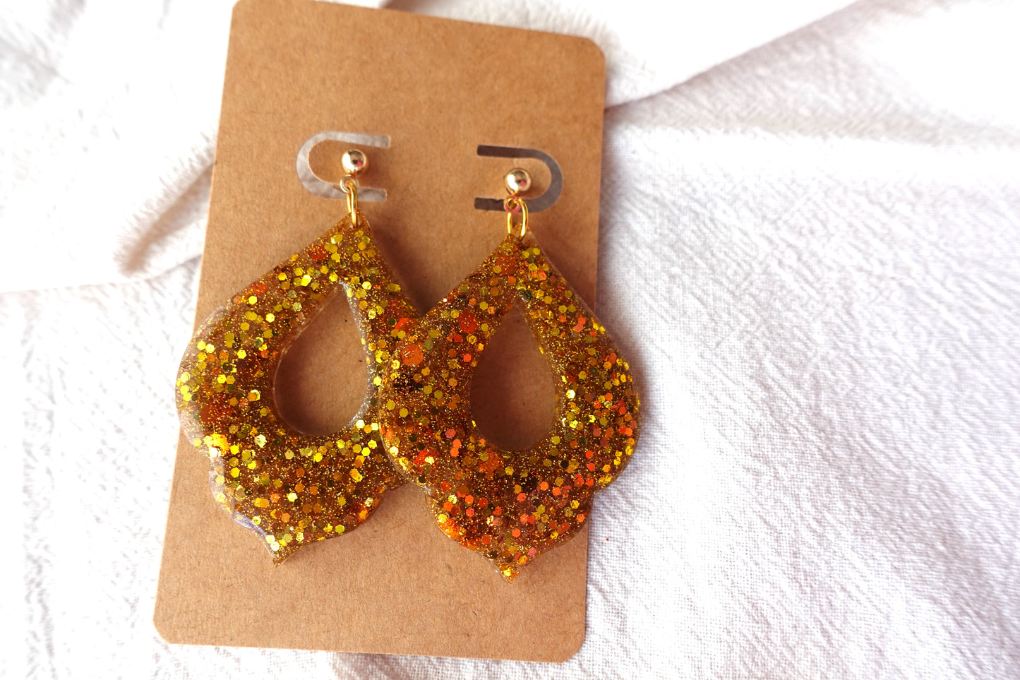Goudkleurige holografische glitter oorbellen (Marokkaanse donut) met goudkleurige knopjes