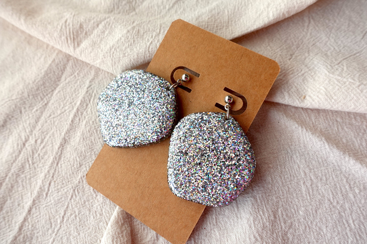 Organische oorbellen met zilverkleurig knopje (zilverkleurige holografische glitter)