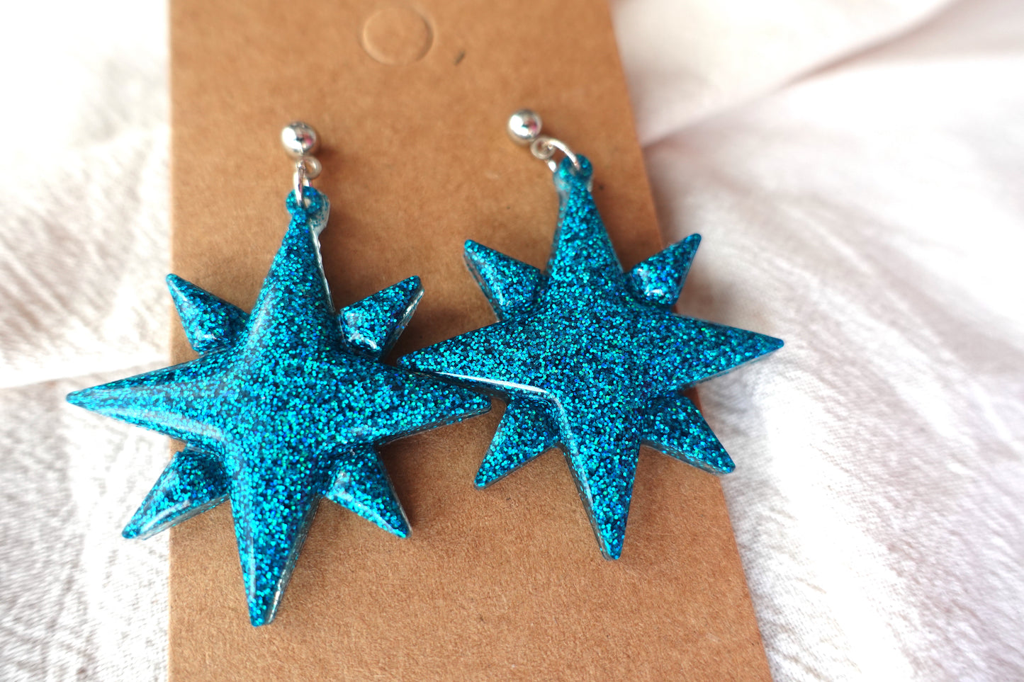 Kerst ster oorbellen met zilverkleurig knopje (turquoise holografische glitter)