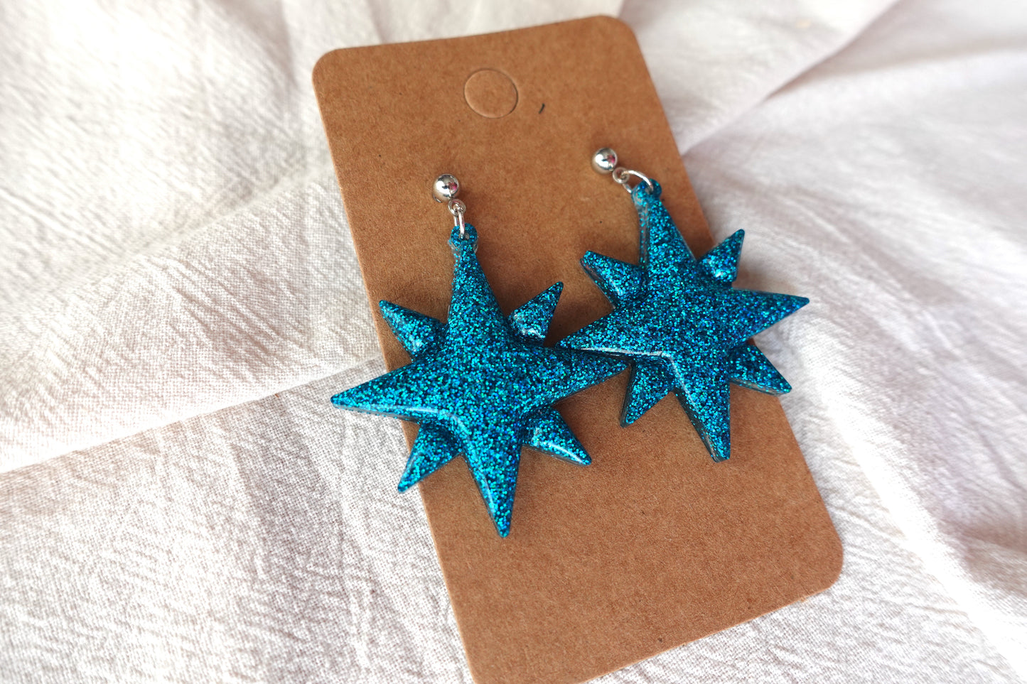 Kerst ster oorbellen met zilverkleurig knopje (turquoise holografische glitter)